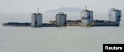 Barges are seen during a salvage operation of sunken ferry Sewol at the sea off Jindo, South Korea, March 22, 2017.