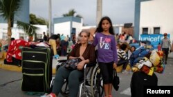 La migrante venezolana Iris Mejías, de 68 años, posa con su nieta Victoria, de 10, mientras descansan en el centro de servicio fronterizo ecuatoriano-peruano, antes de continuar su viaje a Lima, en las afueras de Tumbes, Perú, el 15 de junio de 2019.