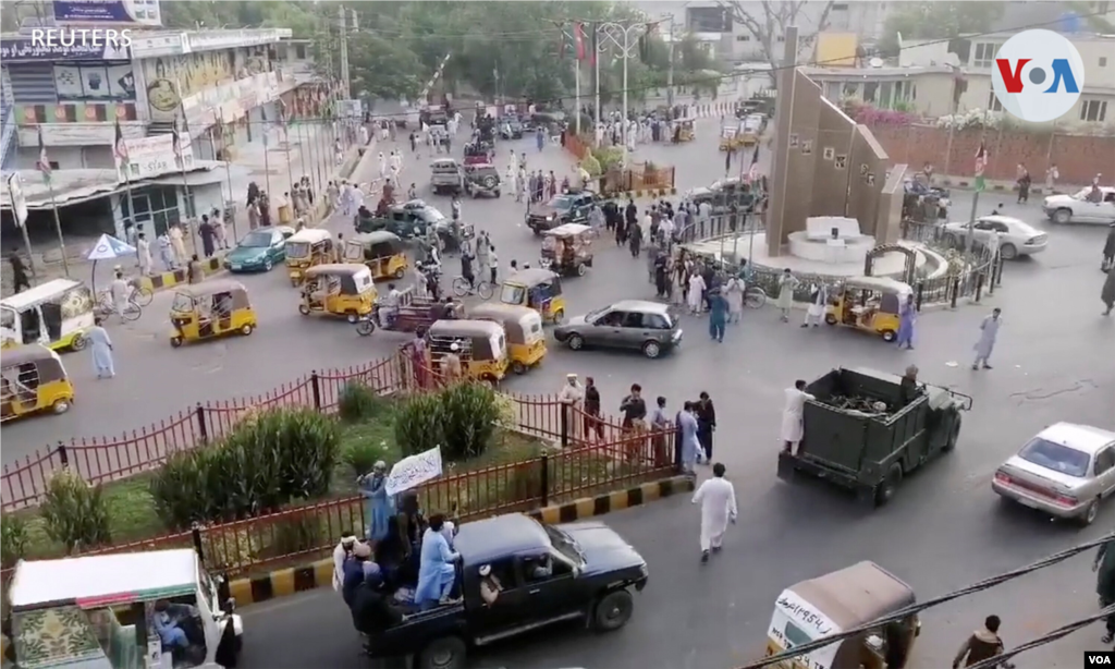 Militantes talibanes ondeando una bandera talib&#225;n en la parte trasera de una camioneta pasan por una calle concurrida en el &#225;rea de la plaza Pashtunistan en Jalalabad, Afganist&#225;n. 