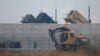 FILE - A truck moves past U.S. Army Patriot missile air defense artillery batteries at U.S. Osan air base in Osan, south of Seoul.