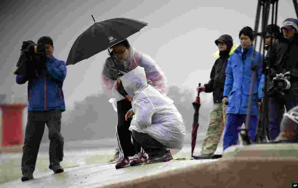 A TV cameraman films weeping relatives of the missing passengers from the sunken ferry, Sewol, at a port in Jindo, South Korea, April 17, 2014.&nbsp;