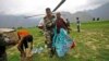 Indian army soldier helps an injured Indian pilgrim after she was rescued from the higher reaches of mountains, at a makeshift helipad at Joshimath, in northern Indian state of Uttarakhand,June 24, 2013.