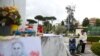 La gente reza junto a la estatua del difunto Papa Juan Pablo II afuera del Hospital Gemelli, donde el Papa Francisco está ingresado para recibir tratamiento por neumonía, en Roma, Italia, el 13 de marzo de 2025.