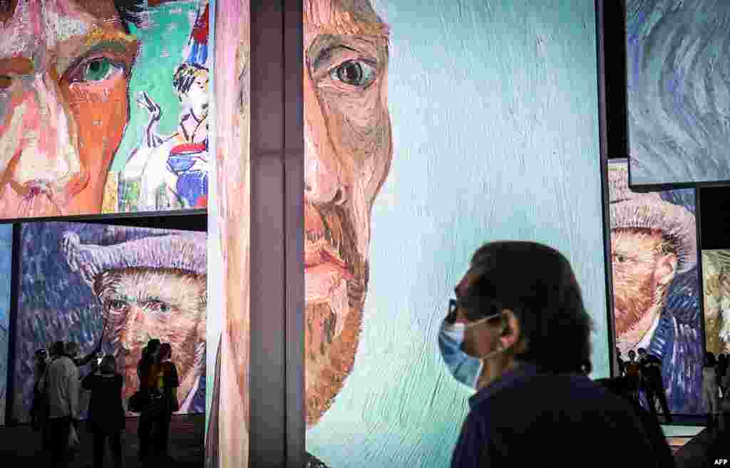 Members of the media wearing face masks look at an exhibition titled &lsquo;Van Gogh Alive&rsquo; during a media preview at the Royal Hall of Industries in Sydney, Australia.