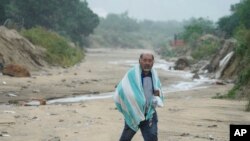 Un hombre camina sobre el barro causado por el huracán Norma en San José del Cabo, México, el sábado 21 de octubre de 2023. Norma se debilitó y fue degradado a Categoría 1 en la escala de vientos de huracanes.
