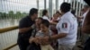 FILE - A Honduras migrant mother and her son walk through the bridge after crossing the border between Guatemala and Mexico, in Ciudad Hidalgo, Mexico, Oct. 20, 2018.