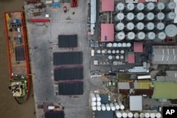 Un barco de suministros, a la izquierda, espera ser cargado en el río Demerara en Georgetown, Guyana, el martes 11 de abril de 2023. (Foto AP/Matías Delacroix)