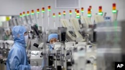 资料照片：穿着防护设备的员工在位于北京的中国瑞萨电子半导体生产工厂工作。(2020年5月14日）