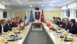 Heading their delegations, Turkey's Foreign Minister Mevlut Cavusoglu, 2nd right, and European Commissioner for Immigration Dimitris Avramopoulos, left, attend a meeting to discuss cooperation on migration management in Ankara, Turkey, Oct. 4, 2019.
