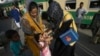 FILE - A Pakistani health worker gives a polio vaccine to a girl at Karachi railway station in Pakistan, April 11, 2018. 