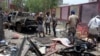Fighters loyal to the government gather at the site of a suicide car bombing in Yemen’s southern city of Aden, Yemen, Aug. 29, 2016. The bombing claimed by the Islamic State group in Aden has killed over 50 pro-government troops.
