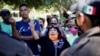 Migrantes hablan con miembros del Instituto Nacional de Migración (INM) de México en un campamento improvisado cerca de la frontera con Estados Unidos, en Ciudad Acuña, México, el 23 de septiembre de 2021.