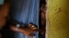  FILE - A 15-year-old girl who was raped when she was 14 talks to a member of UNICEF staff, left, at her home in a village near Masaka, Uganda, June 1, 2017. 