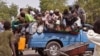 Mutanen kauye a zaune a bayan wata mota a lokacin da suke tserewa rigingimu a kusa da birnin Maiguduri. 