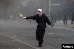 Un manifestante se prepara para lanzar un cóctel Molotov a la policía antidisturbios (no en la foto), durante enfrentamientos con la policía antidisturbios, en una manifestación del Primero de Mayo en Santiago, Chile, el 1 de mayo de 2024.