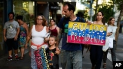 ARCHIVO - Un migrante venezolano porta un cartel en apoyo a Juan Guaidó en Montevideo, Uruguay, el 7 de febrero de 2019.