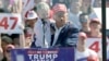 Republican presidential nominee former President Donald Trump holds his grandson Luke Trump as he speaks at a campaign event at Wilmington International Airport in Wilmington, North Carolina, Sept. 21, 2024. 