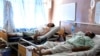FILE - Wounded Afghans lie on beds at a hospital after a bomb attack on election day in Kandahar province, south of Kabul, Afghanistan, Sept. 28, 2019.