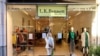 Una mujer mira una tienda cerrada en Kings Road, en Chelsea, Londres, mientras el gobierno británico impone un conjunto de restricciones escalonadas más estrictas en medio de la pandemia de COVID-19, el 20 de diciembre de 2020.