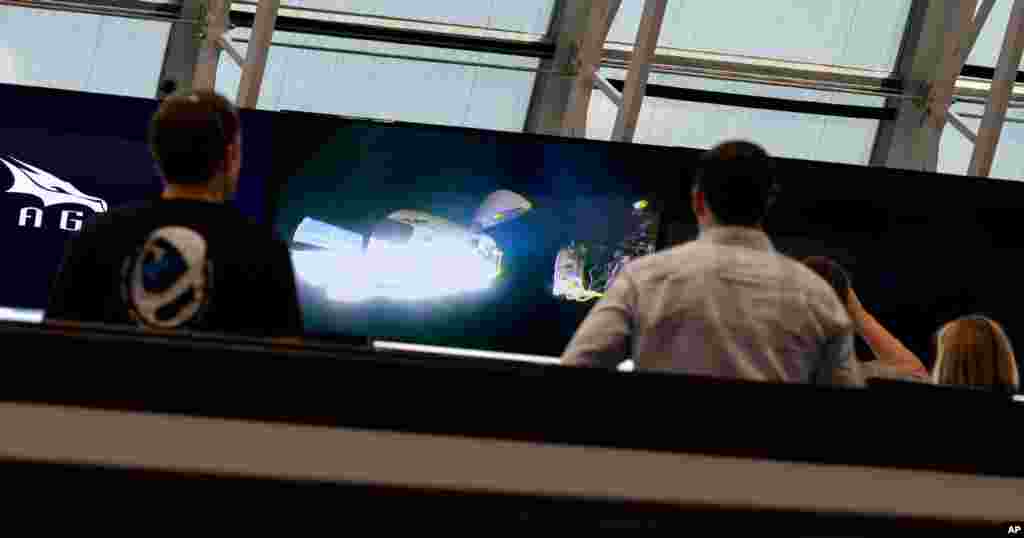 Una vista de la nave espacial Crew Dragon de SpaceX con los astronautas de la NASA Douglas Hurley y Robert Behnken a bordo, se ve en los monitores en la sala de tiro cuatro del Control de Lanzamiento.