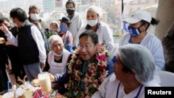 Luis Arce, el candidato del Movimiento al Socialismo (MAS), quien lidera las encuestas, comparte con trabajadores de un mercado de verduras en La Paz, Bolivia, el 10 de octubre de 2020.