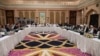 FILE - A handout photo released by the official Qatar's Ministry of Foreign Affairs on Feb. 26, 2019, shows Qatari officials, center, taking part in meeting between the U.S. delegation, left, and the Taliban delegation in Doha. 