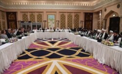 FILE - A handout photo released by Qatar's Ministry of Foreign Affairs on Feb. 26, 2019, shows Qatari officials, center, taking part in a meeting between U.S. officials, left, and members of the Taliban delegation in Doha.
