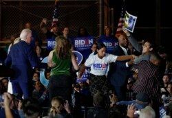 Mientras el exvicepresidente Biden hablaba a la multitud en Los Ángeles, dos mujeres subieron al escenario a protestar. protestan LA