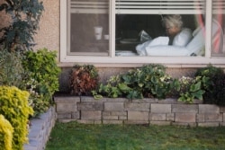 Judie Shape, de 81 años, quien dio positivo al coronavirus, lee desde su cama en Life Care Center de Kirkland, en el área de Seattle, Washington.