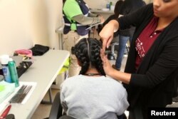 Una persona peina a una niña en una ciudad de tiendas de campaña levantada por el gobierno de Estados Unidos en Tornillo, Texas, para albergar a menores separados de sus padres o que han cruzado la frontera sin acompañamiento. Foto, Departamento de Salud y Servicios Humanos de EE.UU.