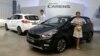 Models pose next to Kia Motors Corp.'s New Carens during its unveiling in Seoul, South Korea, Tuesday, July 26, 2016.