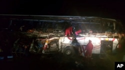 ARCHIVO - En esta fotografía publicada por la Policía Boliviana de Oruro, los bomberos trabajan para rescatar a los pasajeros después de que un autobús chocó de frente con un camión volquete, en las afueras de Machamarca, Bolivia, el lunes 18 de febrero de 2019.