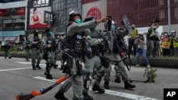 La policía antidisturbios usa gas pimienta contra los manifestantes cuando uno deja caer su arma durante una manifestación contra la legislación de seguridad nacional de Beijing en Causeway Bay en Hong Kong, el domingo 24 de mayo de 2020.