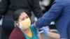 Una mujer recibe una vacuna contra la enfermedad por coronavirus (COVID-19), en Jordan Downs en Los Ángeles, California, EE. UU., 10 de marzo de 2021.
