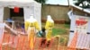 FILE - Health workers walk with a boy suspected of having been infected with the Ebola virus, at an Ebola treatment center in Beni, near Congo's border with Uganda, Sept. 9, 2018.
