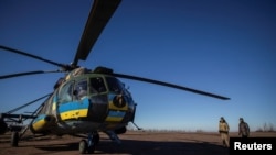 Pilotos militares ucranianos se ven cerca de un helicóptero, en medio del ataque de Rusia a Ucrania, en la región de Donbas, Ucrania, 25 de enero de 2023. REUTERS/Oleksandr Ratushniak