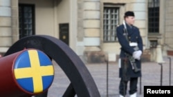 ARCHIVO - Un soldado sueco hace guardia junto a un cañón ceremonial en el patio del Palacio Real de Estocolmo, Suecia, el 25 de febrero de 2024.