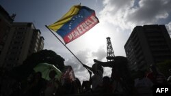 ARCHIVO - Un partidario del presidente y candidato presidencial venezolano Nicolás Maduro ondea una bandera venezolana durante una manifestación en Caracas el 4 de julio de 2024.