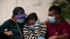 Familiares lloran la muerte de un ser querido, víctima de COVID-19, frente al cementerio municipal de La Bermeja en San Salvador, el 27 de julio de 2020.