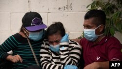 Familiares lloran la muerte de un ser querido, víctima de COVID-19, frente al cementerio municipal de La Bermeja en San Salvador, el 27 de julio de 2020.