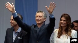 El presidente argentino Mauricio Macri saluda a sus partidarios, acompañado de su compañero de binomio Miguel Angel Pichetto (izq.) y de la primera dama Juliana Awada (der.) en una concentración cerca del Obelisco en Buenos Aires, el sábado 19 de octubre de 2019. AFP/Alejandro Pagni.