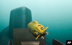 A computer simulation shows a Russian nuclear-powered underwater drone being released by a submarine.