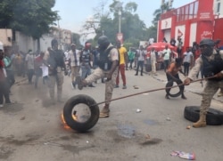 La policía retira una llanta en llamas mientras los haitianos organizan una huelga nacional para protestar contra la creciente ola de secuestros, días después del secuestro de un grupo de misioneros, en Puerto Príncipe, Haití, el 18 de octubre de 2021.