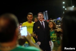 El presidente electo de Brasil, Jair Bolsonaro, observa el júbilo de partidarios que reaccionan después de que ganó la contienda presidencial. Brasilia, 28 de octubre de 2018. REUTERS / Adriano Machado.