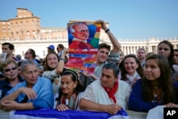 Fieles en El Vaticano siguen la ceremonia de canonización de dos de las más importantes figuras de la Iglesia Católica en el Siglo XX, el asesinado arzobispo salvadoreño Óscar Romero y el Papa Paulo VI, el domingo 14 de octubre de 2018. Otros cinco beatos también fueron elevados a la santidad.