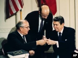 1987年苏联领导人戈尔巴乔夫和美国总统里根在签署美苏中程核导弹条约后换笔（1987年12月8日）