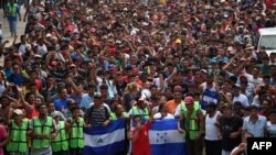 Migrantes hondureños viajando en caravana hacia EE.UU. celebran una manifestación demandando a las autoridades que permitan al resto del grupo cruzar en Ciudad Hidalgo, en el estado de Chiapas state, Mexico después de cruzar desde Guatemala el 20 de octubre del 2018.