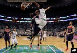 Boston Celtics forward Jaylen Brown (7) dunks over Washington Wizards guard Bojan Bogdanovic during the fourth quarter of Game 7 of a second-round NBA basketball playoff series, May 15, 2017, in Boston.