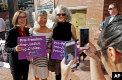 La gobernadora de Oregón, Kate Brown, a la izquierda, posa para fotos con simpatizantes después de un mitin en Portland, Oregon, 17 de octubre de 2018.
