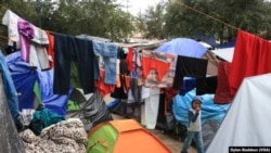 Un niño camina entre la ropa puesta a secar después de una intensa lluvia en el campamento de carpas de Reynosa, México. Foto Dylan Baddour/VOA.
